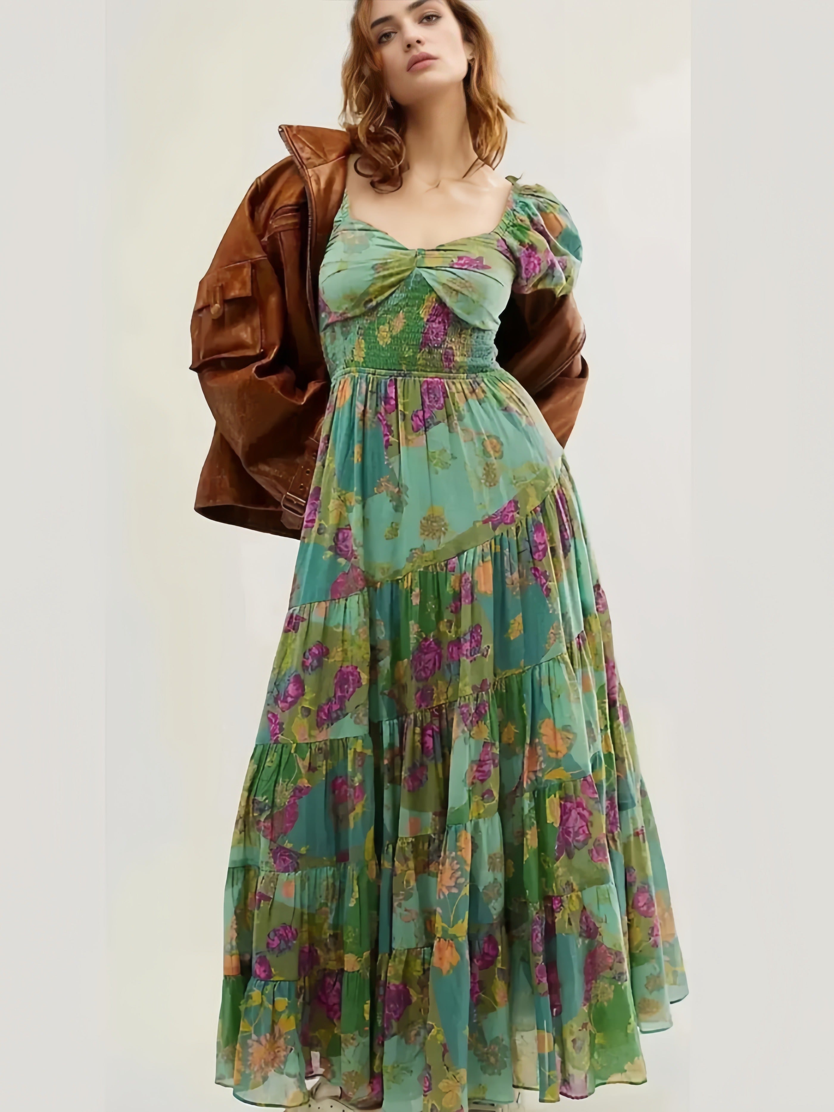 Woman wearing a floral dress with a brown jacket on a white background
