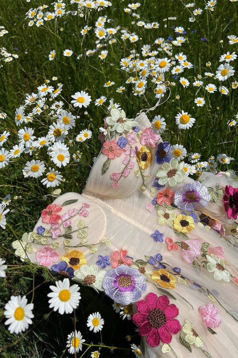 Person wearing a floral dress standing in a field of daisies