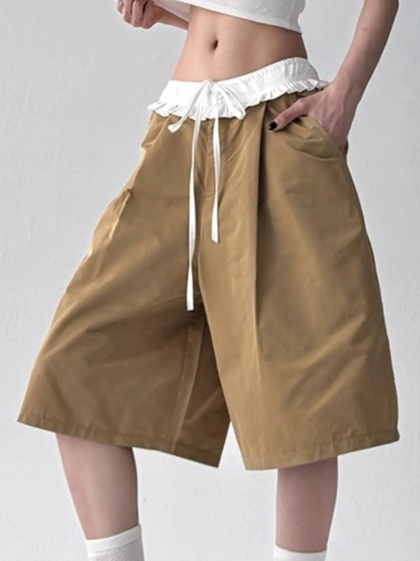 Woman wearing The Wide Short, black wide-leg drawstring shorts from HOORR