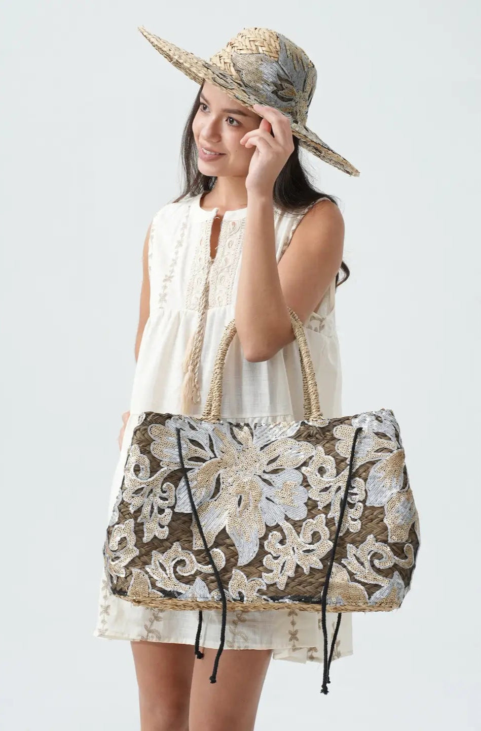 Woman holding a floral-patterned bag against a white background